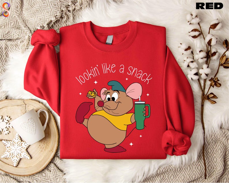 May include: Red sweatshirt with a cartoon mouse holding a piece of cheese and a green drink. The text on the sweatshirt reads 'lookin' like a snack'.