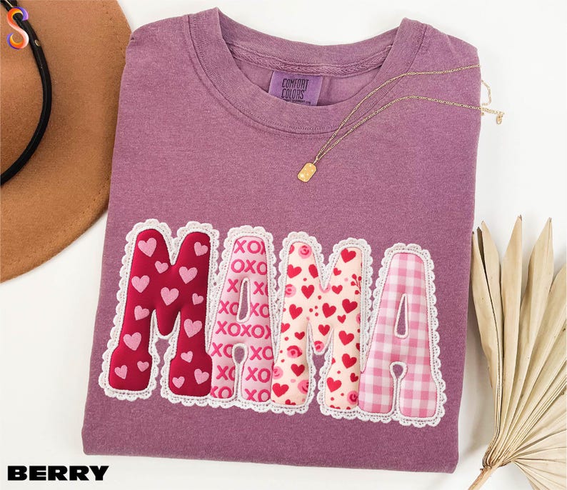 a purple t-shirt with the word "MAMA" printed on it, along with a necklace and a hat.