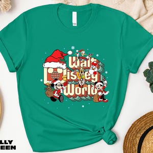 A green t-shirt with a graphic design featuring characters from Disney's "Walt Disney World" and the text "Walt Disney World" printed on it.