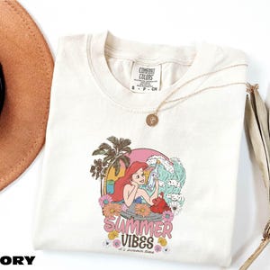 a hat, sunglasses, and t - shirt on a white surface