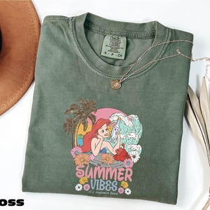 a green shirt with a picture of a mermaid on it