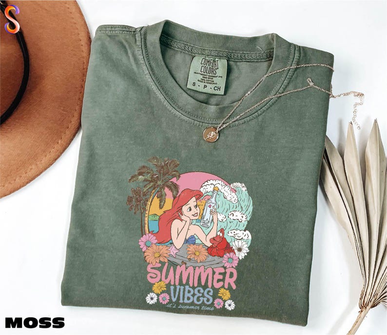 a green shirt with a picture of a mermaid on it