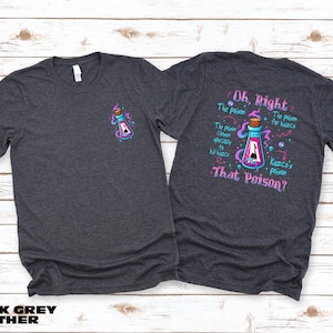 a gray t-shirt with a colorful graphic design on the back, featuring a bottle with a skull and crossbones symbol, and text that reads "Oh, Right! The poison is that poison!"