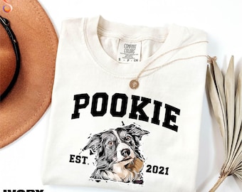 May include: Ivory t-shirt with a black graphic of a dog with the text "POOKIE EST. 2021"