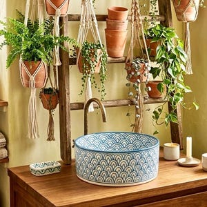 Peut inclure: Ensemble de trois mugs en céramique avec une finition mate et mouchetée. Les tasses sont de couleur crème, gris clair et gris foncé. Chaque mug a un design minimaliste et une anse arrondie.