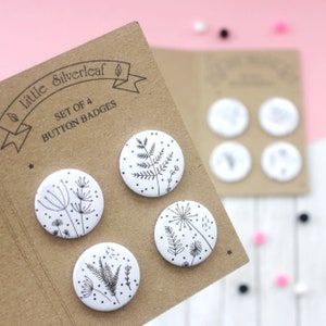 May include: Set of four white button badges featuring black line drawings of various plants and flowers. The badges are presented on a brown card with the text "little silverleaf" and "Set of 4 Button Badges".
