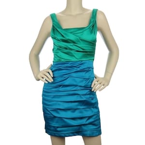 May include: A two-tone, sleeveless dress in teal and emerald green. The bodice is emerald green with a draped neckline, while the skirt is teal with horizontal pleats. The dress is made of a shiny, satin-like material.