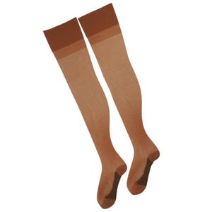 Puede incluir: Un par de medias altas hasta el muslo, transparentes, de color beige claro. Las medias tienen una banda marrón oscuro en la parte superior y punteras reforzadas. El material parece ser nailon o una tela transparente similar. Las medias se muestran sobre un fondo blanco.