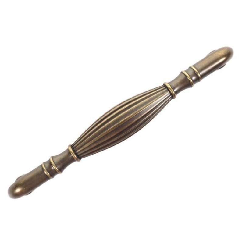 Pode incluir: Um puxador de arm&aacute;rio bronzeado com um centro canelado e an&eacute;is decorativos em cada extremidade. A ferragem tem uma est&eacute;tica vintage. O puxador tem aproximadamente 12,7 cm de comprimento.