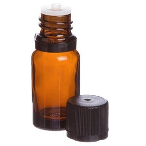 May include: A small amber glass bottle with a black cap and a white dropper top. The bottle is cylindrical with a rounded base. The cap is off to the side, revealing the bottle's opening. The bottle is designed for essential oils or other liquids.