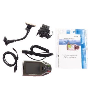 May include: A Magellan RoadMate 760 GPS device with accessories, including a car charger, mounting bracket, and instruction manual. The device has a black and silver design with a touchscreen display. The instruction manual is white and blue.