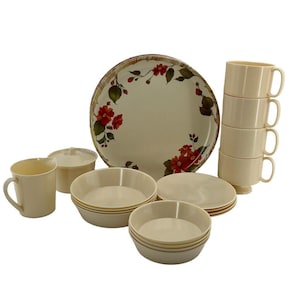 Könnte beinhalten: Ein cremefarbenes Geschirrset mit einem großen Teller mit einem Blumendesign aus roten Blumen und grünen Blättern. Das Set enthält Schalen, Untertassen, Tassen und eine Zuckerdose mit Deckel. Die Teller haben einen Durchmesser von ca. 25 cm.