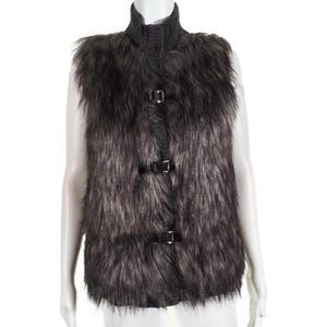 May include: A faux fur vest in shades of grey and black, with a high collar and three black buckle fastenings. The sleeveless vest is made of a soft, textured material.