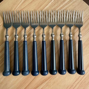 Puede incluir: Juego de diez tenedores de plata con mangos azules. Los tenedores tienen un diseño sencillo y son perfectos para el uso diario.