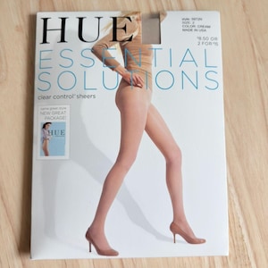 以下が含まれることがあります： クリーム色のHue Essential Solutionsクリアコントロールストッキング、サイズ2の長方形の製品パッケージ。パッケージには、ストッキングとハイヒールを着用した人物のグラフィックが描かれており、ブランド名やスタイルの詳細が記載されています。