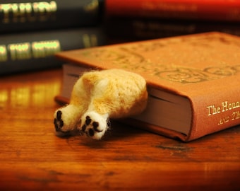 May include: A brown book with gold lettering that reads "The Hound of the Baskervilles and The Valley of Fear" with a felt dog bookmark sticking out of the top.