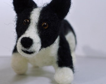 Puede incluir: Figura de perro de fieltro en blanco y negro. El perro tiene la cara blanca, las orejas negras y el cuerpo negro. Los ojos del perro son marrones. La figura está de pie.