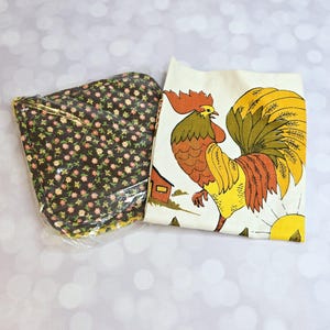 Puede incluir: Un juego de dos agarraderas de cocina marrones y blancas. Una agarradera tiene un patrón floral y la otra tiene un diseño de gallo y sol.