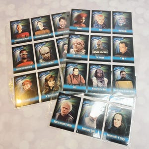 Puede incluir: Una colección de cromos de Star Trek con varios personajes de la serie. Las cartas están en fundas protectoras e incluyen imágenes del Capitán Picard, Data y otros personajes. Las cartas están en una carpeta de plástico transparente.