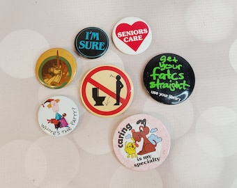 May include: A collection of ten colourful button badges with various designs and sayings. The badges feature a unicorn, a toilet, a dog, and text such as "I'm Sure", "Seniors Care", and "Get Your Facts Straight".