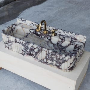 Honed marble sink in Calacatta Viola, showcasing rich veining and natural texture, perfect for bespoke bathroom designs.