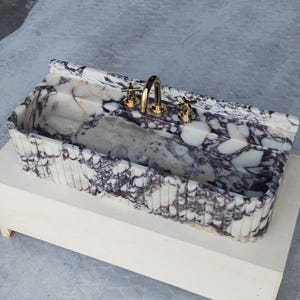 Luxurious marble sink crafted from Calacatta Viola, featuring a honed finish and unique natural patterns for a statement piece.