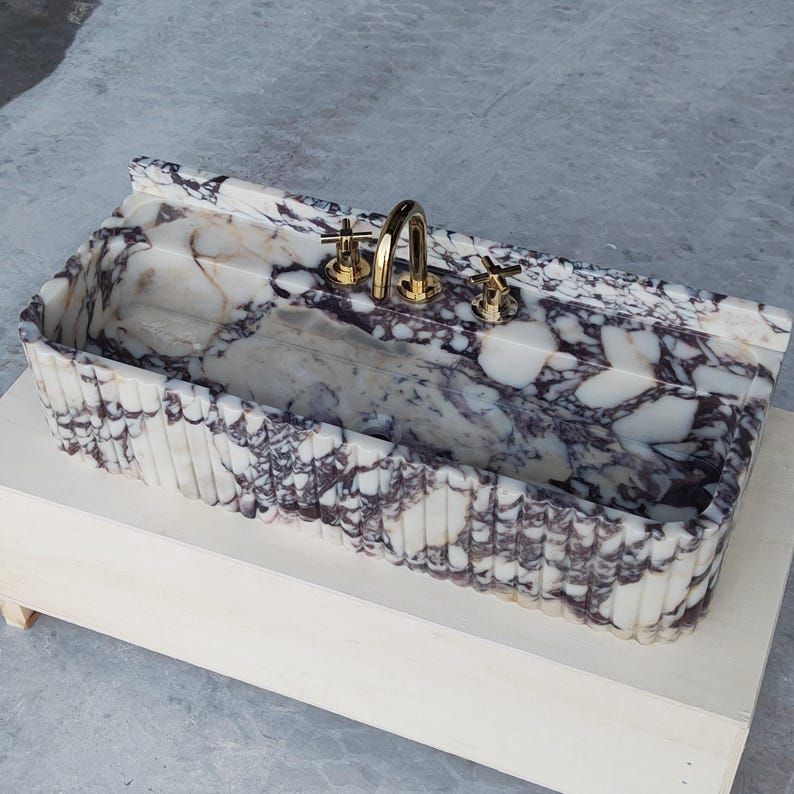 Luxurious marble sink crafted from Calacatta Viola, featuring a honed finish and unique natural patterns for a statement piece.