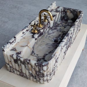 Calacatta Viola marble sink showcasing bold purple veining, perfect for adding timeless elegance to bathrooms or powder rooms.