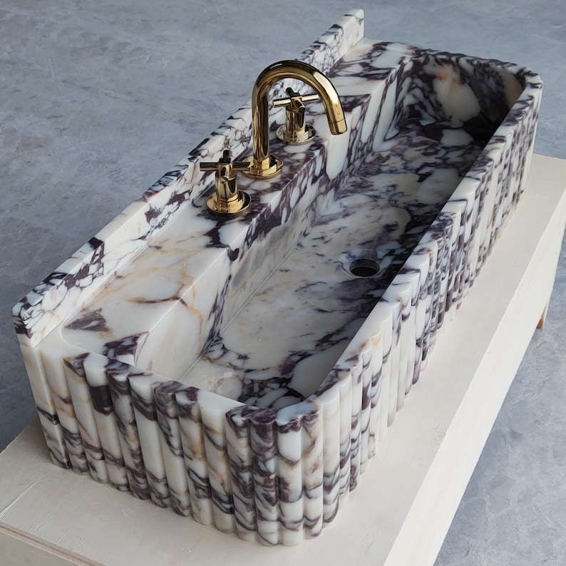 Calacatta Viola marble sink showcasing bold purple veining, perfect for adding timeless elegance to bathrooms or powder rooms.