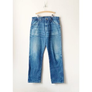 May include: A pair of light blue denim jeans with a straight leg fit. The jeans have a classic five-pocket design and a button fly.
