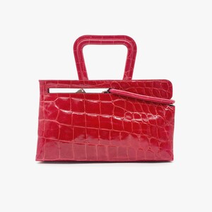 May include: A bright red crocodile embossed leather handbag with a top handle.