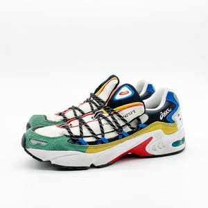 May include: White, green, yellow, blue, and red sneakers with black laces and a black and blue Asics logo on the side. The sneakers have a white sole with a red "GEL" logo.