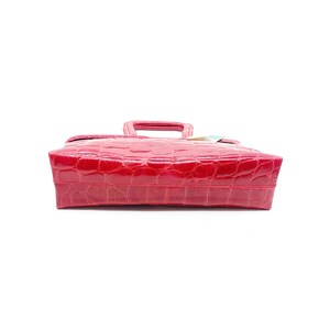 May include: A bright red handbag made of crocodile embossed leather with a double top handle.