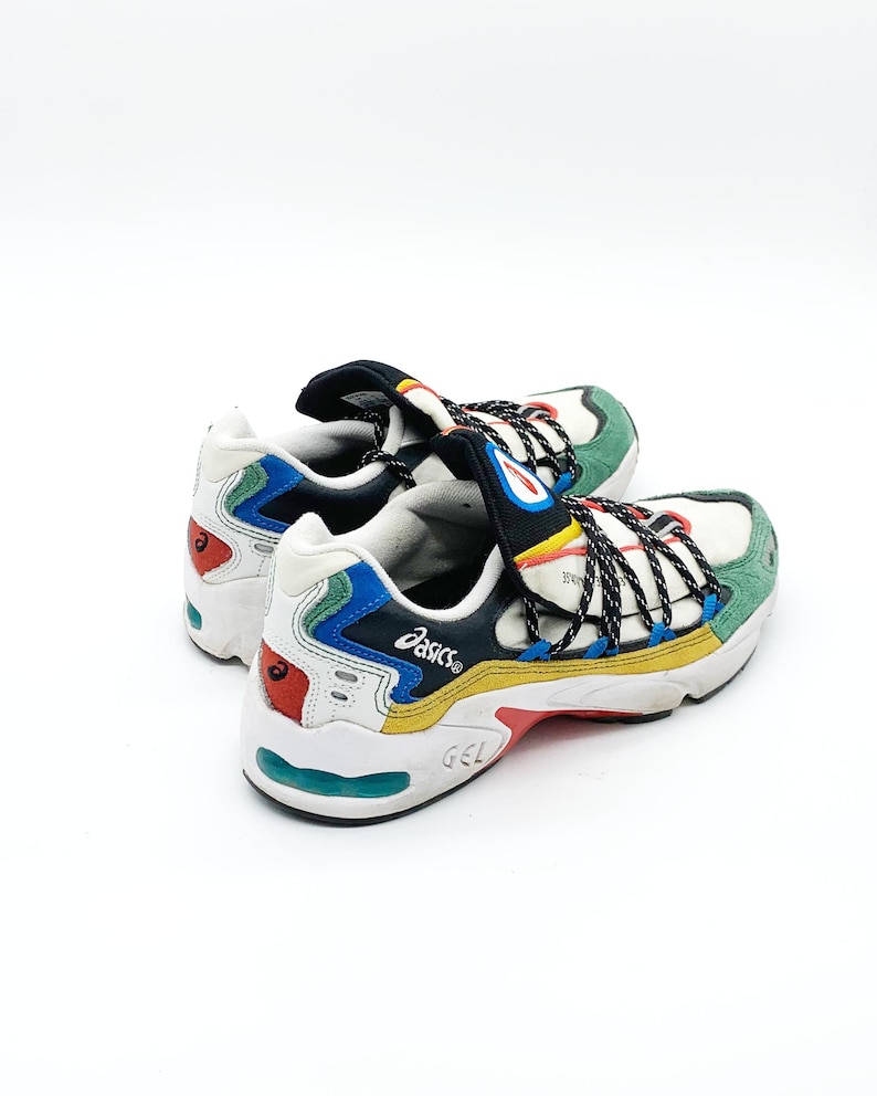 May include: White, black, blue, green, yellow, and red sneakers with black laces and the word "ASICS" on the side.