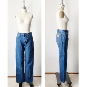 May include: A pair of blue denim jeans with a straight leg fit. The jeans have a high waist and are shown on a mannequin.
