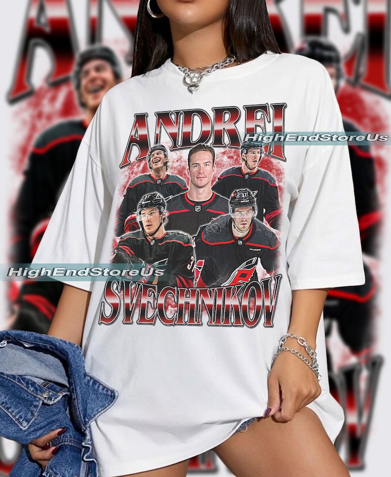 May include: White t-shirt featuring a vintage-style graphic of hockey player Andrei Svechnikov. The design includes the player's name and images of him and other players in black and red uniforms. The text "HighEndStoreUs" is also visible.