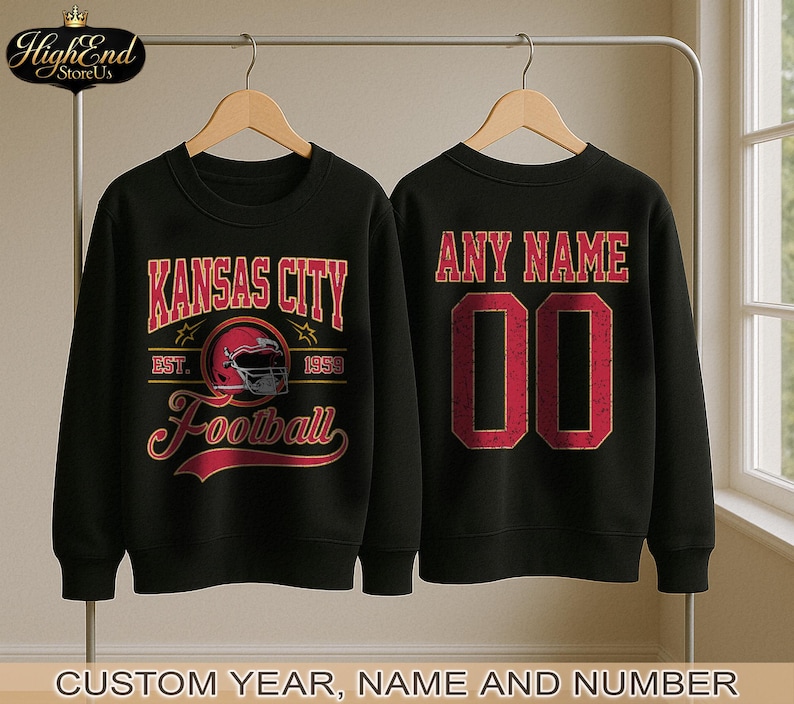 Puede incluir: Dos sudaderas negras con tem&aacute;tica de f&uacute;tbol. Una presenta "Kansas City Football" en letras rojas y doradas con un gr&aacute;fico de casco. La otra tiene "ANY NAME" y el n&uacute;mero "00" en rojo. El texto "CUSTOM YEAR, NAME AND NUMBER" est&aacute; en la parte inferior.