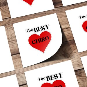 Peut inclure: Un ensemble d'autocollants carrés blancs avec un cœur rouge et le texte "The Best Chiro" imprimé dessus.