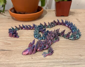 May include: A 3D printed iridescent purple and teal dragon figurine with a spiky, scaly design.