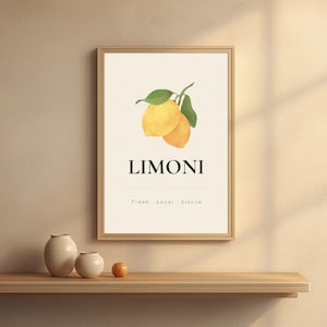 May include: A framed art print featuring two yellow lemons with green leaves, labeled "LIMONI" with "Fresh - Local - Sicilia" below. The print is in a light wood frame, displayed on a wooden shelf with two cream-colored vases and a small orange.