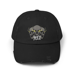 May include: Black distressed baseball cap with a graphic of three skulls with glowing yellow eyes and the word "HEX" in white lettering.