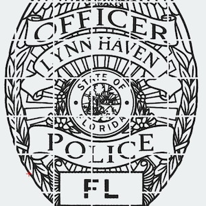 May include: Black and white police officer badge with the words "OFFICER LYNN HAVEN POLICE FL". The badge has a detailed design with an eagle at the top and a circular emblem in the center.