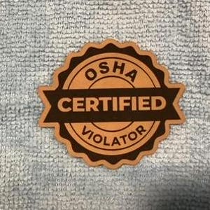 Puede incluir: Una pegatina redonda marrón y negra con el texto "OSHA CERTIFIED VIOLATOR" en una pancarta negra.