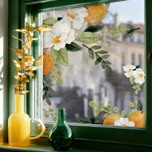 May include: A white ceramic mug with a black handle and the text "But First, Coffee" in a bold, black font. The mug is set against a blurred background, suggesting a cozy setting.