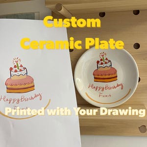 May include: A custom ceramic plate with a hand-drawn birthday cake design. The plate features a colourful cake illustration with the words "Happy Birthday" and "Forest". The text "Printed with Your Drawing" is also visible.