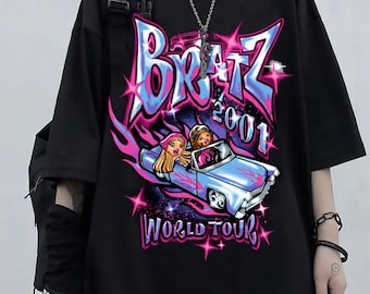 May include: Black t-shirt featuring a graphic design with the text "Bratz 2001 WORLD TOUR". The design includes a blue car with two cartoon characters and pink and blue flames and stars.
