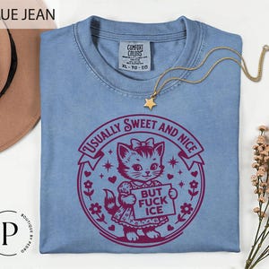a blue t-shirt with a graphic design, a necklace, and some flowers on a white background.