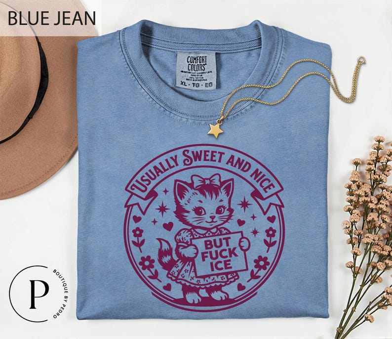 a blue t-shirt with a graphic design, a necklace, and some flowers on a white background.