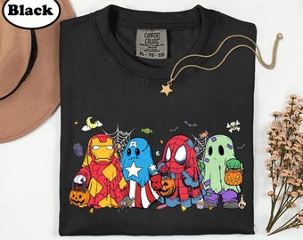 Könnte beinhalten: Ein schwarzes T-Shirt mit einer Grafik von vier Charakteren, die als Geister für Halloween verkleidet sind. Die Figuren ähneln Iron Man, Captain America, Spider-Man und einem klassischen Geist, die jeweils einen Kürbis-Süßigkeiten-Eimer halten.