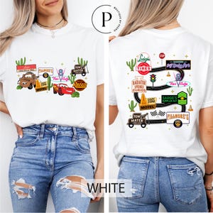 A woman wearing a white t-shirt with various car-related graphics and text printed on it.